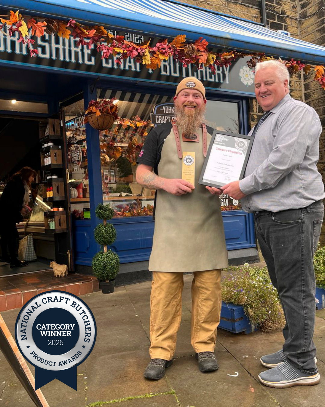 Award presentation outside Yorkshire Craft Butchery, with a framed certificate and 2026 National Craft Butchers Product Awards category winner badge.
